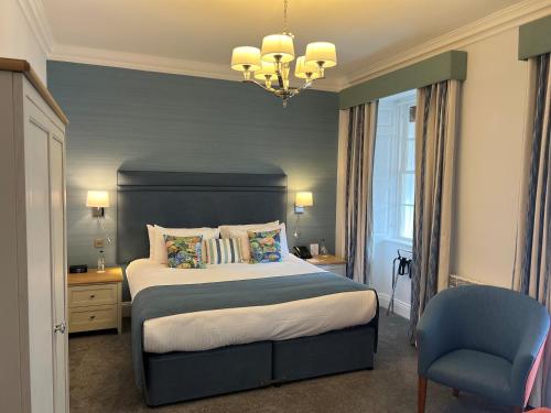 a bedroom with a large bed and a chair at Best Western Hotel de Havelet in St Peter Port
