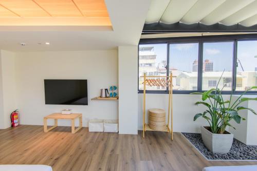 ein Wohnzimmer mit einem Flachbild-TV und einer Topfpflanze in der Unterkunft Fort Provintia in Tainan