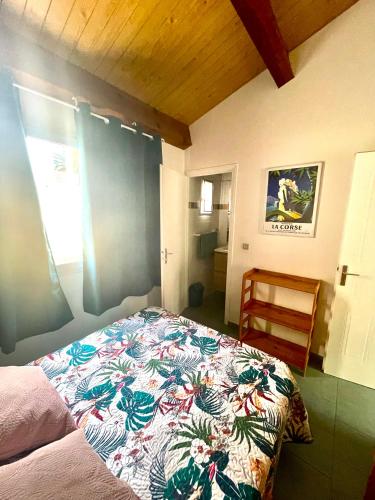- une chambre avec un lit doté d'un couvre-lit coloré dans l'établissement T2 Râteau Bavoir, à Calvi