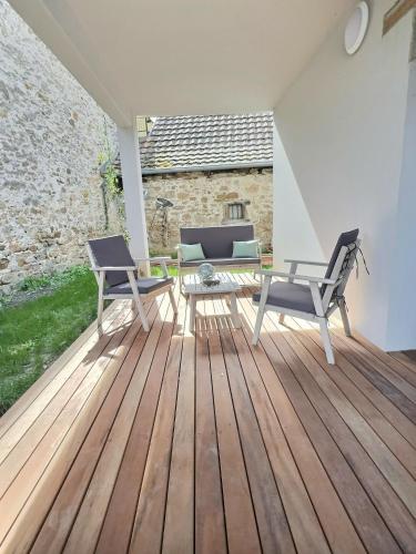 a patio with two chairs and a table on a wooden deck at la parenthèse in Beblenheim