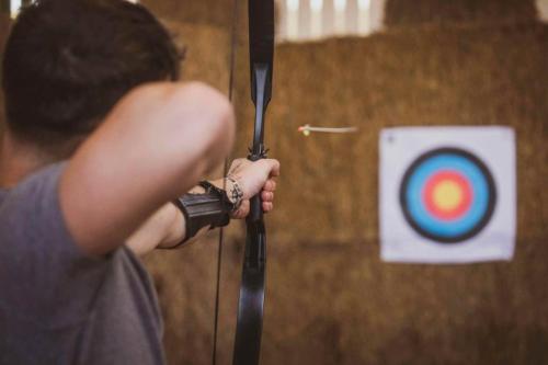 a person holding a arrow in front of a target at Modulog 3 At Tapnell Farm in Yarmouth