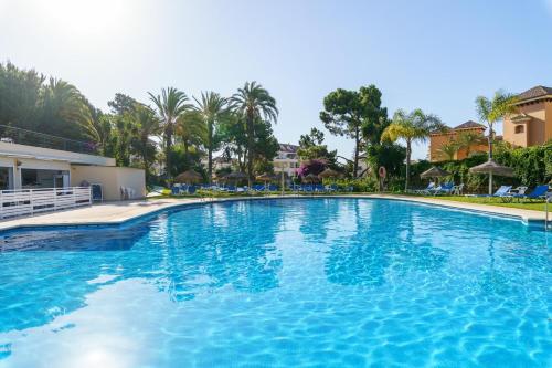 a large pool with blue water in a resort at Marbella Este Next Marriott and Nikki B - Happy Rentals in Marbella
