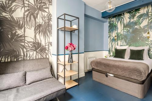 een slaapkamer met een bed en een bank erin bij Luxury 3 Bedroom 2 Bathroom Family Loft in Central in Parijs
