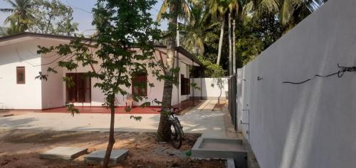 a small tree in front of a white house at Villa Paradiso in Wadduwa