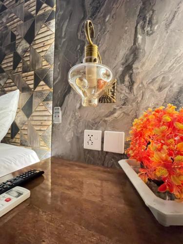 a desk with a lamp and flowers on it at The Life Style Lodges opp Centaurus Mall in Islamabad