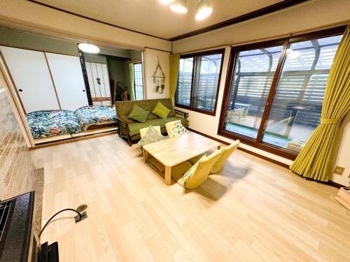 a living room with a couch and a table at Chano Onsen House 温泉付き in Shiraoi