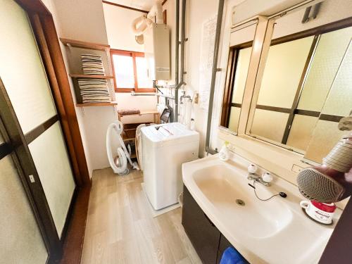 a bathroom with a sink and a refrigerator at Chano Onsen House 温泉付き in Shiraoi