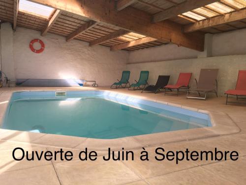 une grande piscine avec des chaises autour dans l'établissement Gites Le Cheval Noir, à Rouillac
