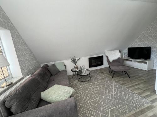 - un salon avec un canapé et une télévision dans l'établissement Ferienwohnung Haus Moorblick Wiesmoor Ostfriesland mit Garten, à Wiesmoor