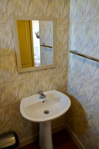 a white sink in a bathroom with a mirror at Cazare Alfredo in Craiova