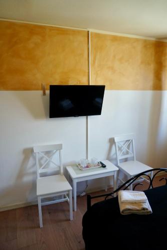 a living room with two chairs and a flat screen tv at Cazare Alfredo in Craiova