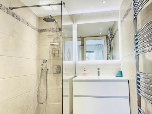 une salle de bain avec un lavabo et une douche dans l'établissement Cannes Palm Beach, à Cannes