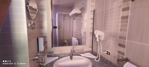 Abū Ghuşūn的住宿－Hostmark Zabargad Beach Resort，一间带水槽的浴室和一部电话