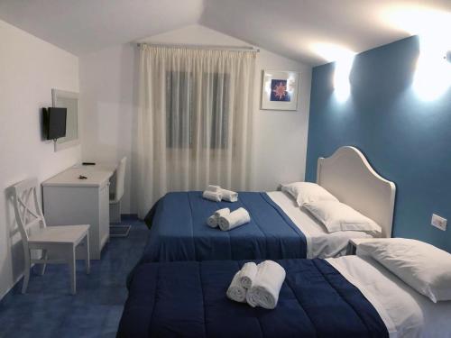 a hotel room with two beds and a desk and a computer at Le Camere della Campana in Castellammare del Golfo