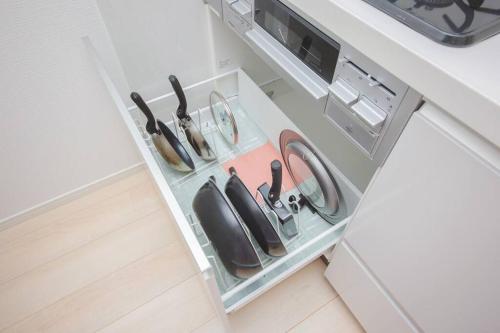 a drawer in a kitchen filled with utensils at Piccola Locanda in Itoman