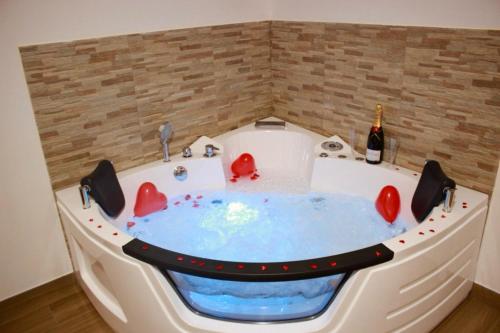 a hot tub in a room with a bottle of wine at MaryGrace B&B in Castellammare di Stabia