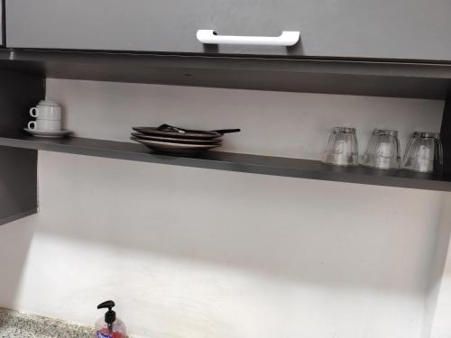 un estante con platos y utensilios. en Gentle Breeze Studio 2, en Amán