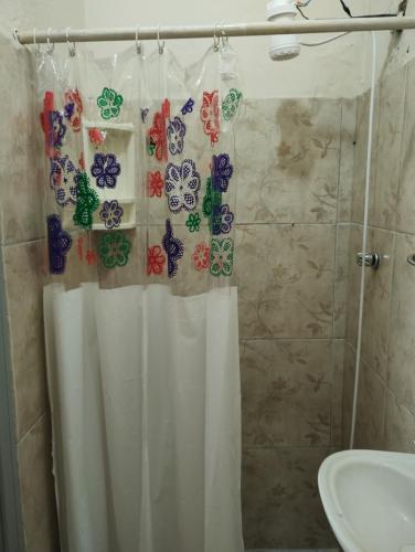 a bathroom with a shower curtain and a sink at Rosane's casa in Guapimirim