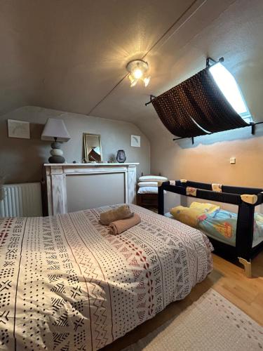 een slaapkamer met een bed met een wit dekbed bij Cottage La petite guette in Le Val-Saint-Père