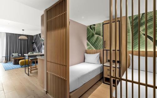 a small bedroom with a bed and a desk at Royal Garden by Isrotel Collection in Eilat