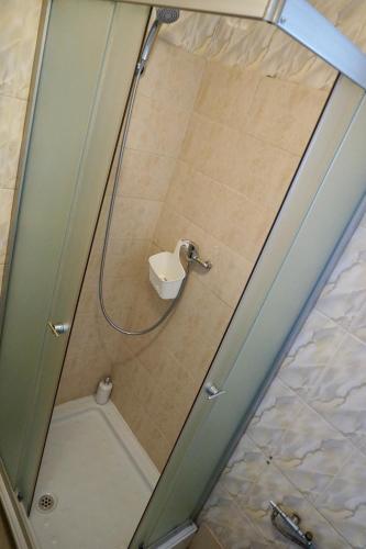 a shower with a glass door with a toilet at Cazare Alfredo in Craiova