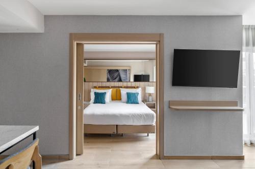 a bedroom with a bed and a flat screen tv at Royal Garden by Isrotel Collection in Eilat