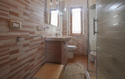La salle de bains est pourvue d'un lavabo, de toilettes et d'une douche. dans l'établissement 3 Bedroom Cozy Apartment In Scalea, à Scalea