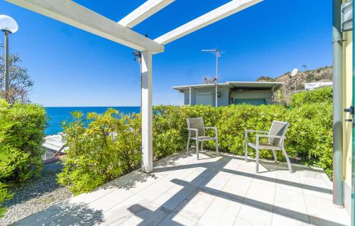 a patio with two chairs and the ocean in the background at Stunning Apartment In Framura With Wifi in Framura