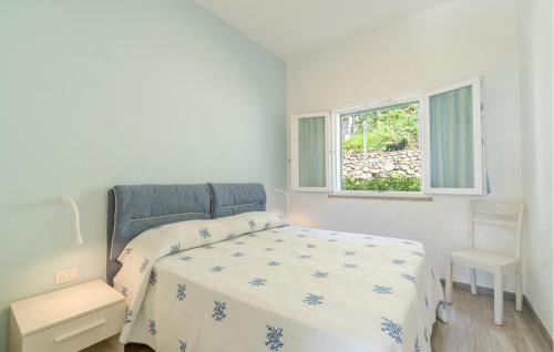 a white bedroom with a bed and a window at Stunning Apartment In Framura With Wifi in Framura