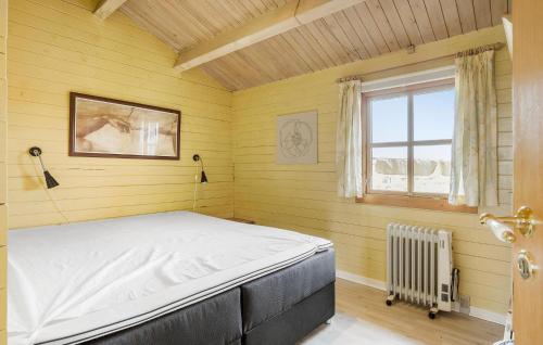 Lovely Home In Bogense With Kitchen في بوجنسي: غرفة نوم بسرير في غرفة صفراء مع نافذة