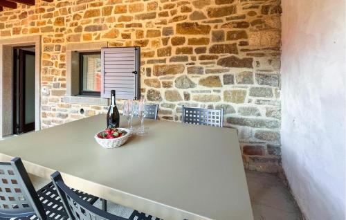 a table with a bottle of wine and a basket of fruit at Beautiful Apartment In Castel Focognano in Castel Focognano