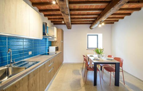 a kitchen with a table with chairs and a sink at Beautiful Apartment In Castel Focognano in Castel Focognano