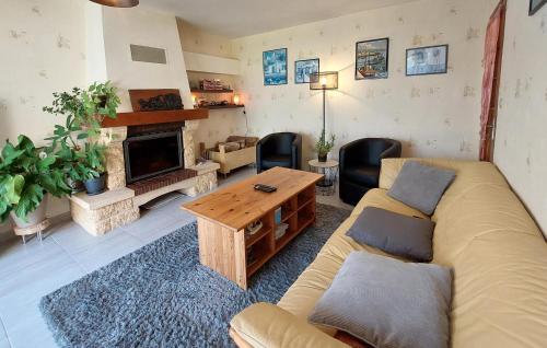 un salon avec un canapé et une cheminée dans l'établissement Cozy Home In Locquénolé With Kitchen, à Locquénolé