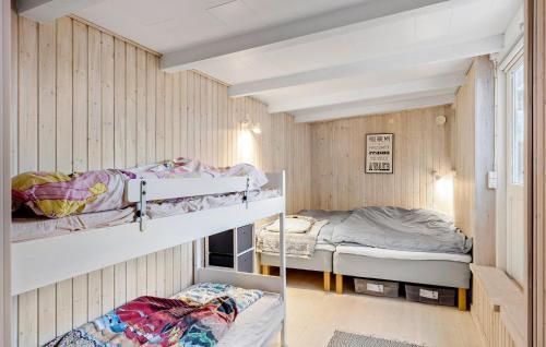 オテルプにあるAwesome Home In Otterup With Kitchenの木製の壁の客室で、二段ベッド2組が備わります。