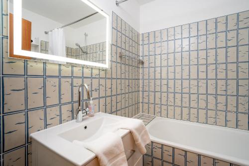 uma casa de banho com um lavatório e uma banheira em HOF 306 - Berliner Hof - Seeblick em Scharbeutz
