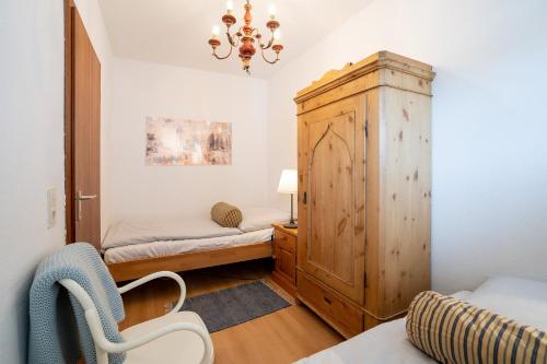 um quarto com 2 camas e um armário de madeira em HOF 306 - Berliner Hof - Seeblick em Scharbeutz