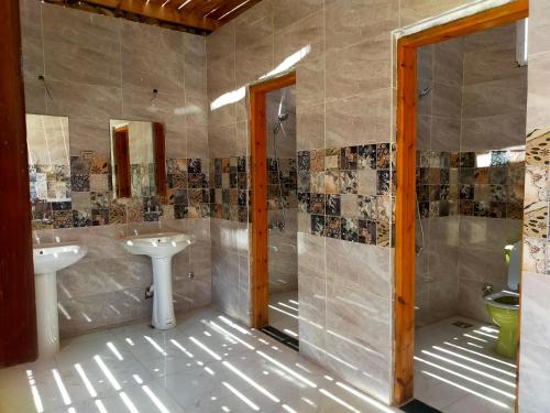 uma casa de banho com 2 lavatórios e um chuveiro em Blue Bus Camp Resort em Nuweiba