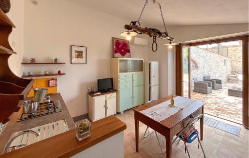 a kitchen with a table and a kitchen with a refrigerator at Nice Home In Petroro With Wifi in Petroro
