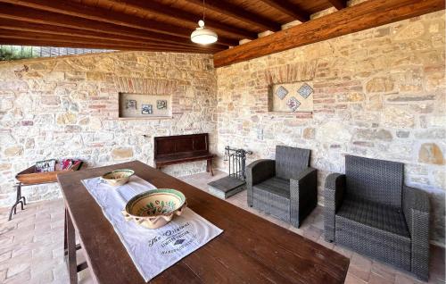 a living room with a table and chairs and a stone wall at Nice Home In Petroro With Wifi in Petroro