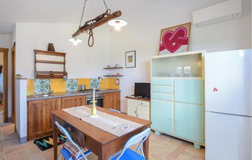 a kitchen with a table and a white refrigerator at Nice Home In Petroro With Wifi in Petroro