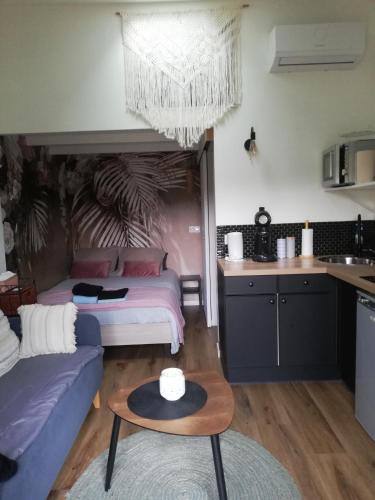 un salon avec deux lits et une table dans l'établissement Petit cocon avec terrasse, à LʼIsle-sur-la-Sorgue