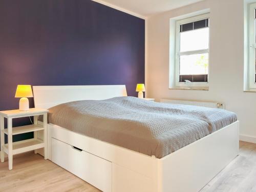 ein Schlafzimmer mit einem großen weißen Bett und zwei Lampen in der Unterkunft Sünnslag Wohnung 054 in Boltenhagen