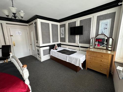 a bedroom with a bed and a mirror and a dresser at The Barrington Guesthouse Hotel in Scarborough