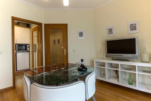 Una sala de estar con una mesa y un televisor. en GuestReady - Cozy Luis I Apartment, en Vila Nova de Gaia