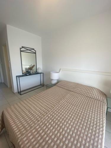 Habitación blanca con cama y espejo en Milos Apartments, en Afitos