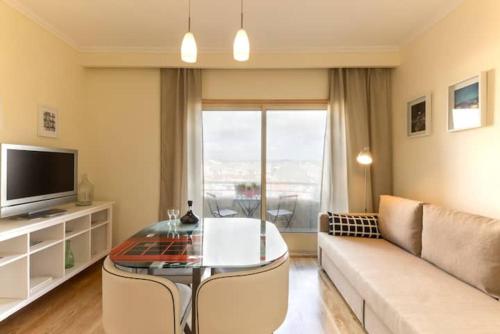 Una sala de estar con un sofá y una mesa de cristal. en GuestReady - Cozy Luis I Apartment, en Vila Nova de Gaia