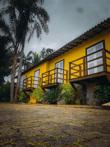 a yellow house with balconies on the side of it at Pousada Éden in Angra dos Reis