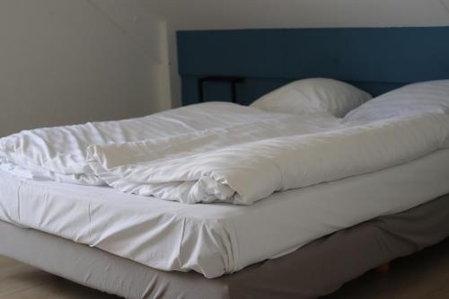 d'un lit non aménagé avec des draps et des oreillers blancs. dans l'établissement Comfortabel 6p vakantiehuis met laadpaal, à Ewijk