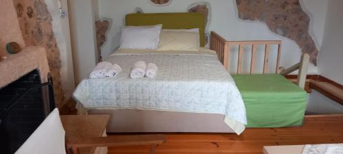 a bedroom with a bed with two slippers on it at MELPO in Évyiros
