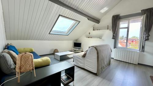 un salon avec un canapé et une fenêtre dans l'établissement Les Tilleuls, au Crotoy